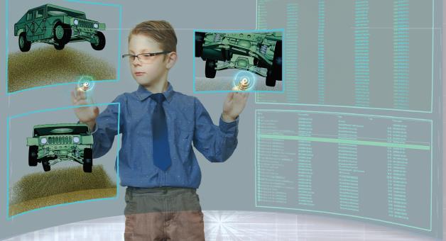 A boy in glasses and tie is playing with an interactive screen.