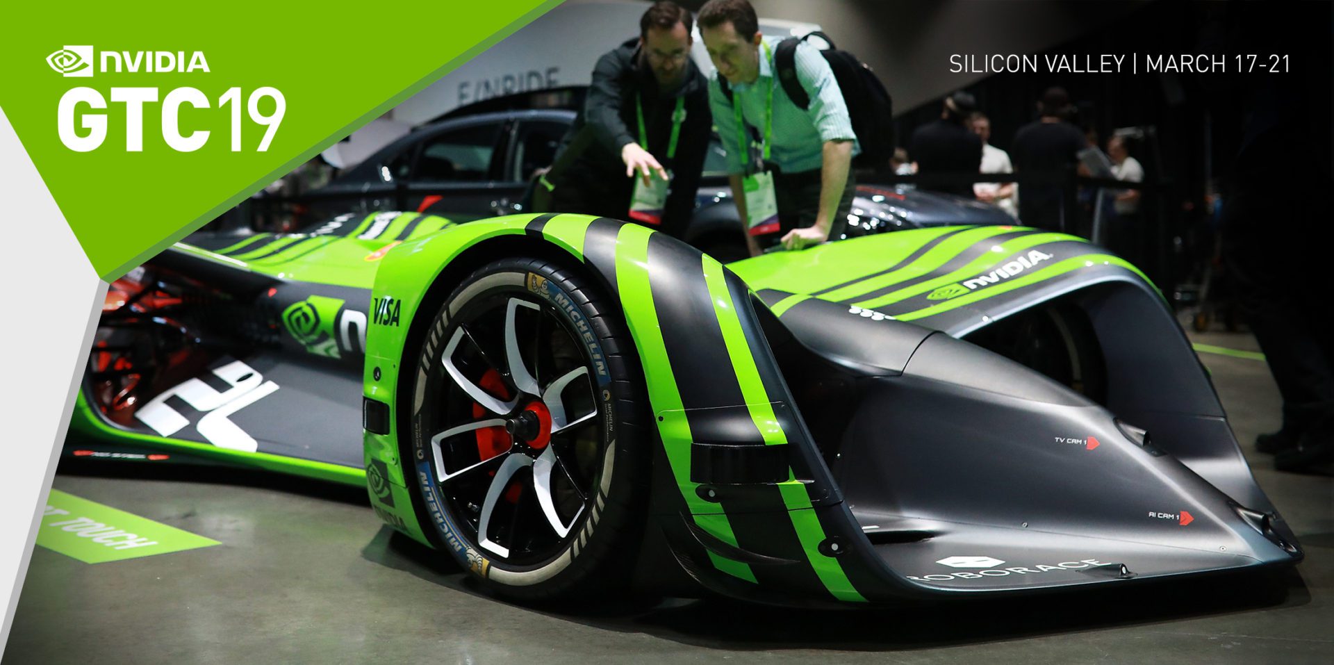 Two people are standing next to a green car.